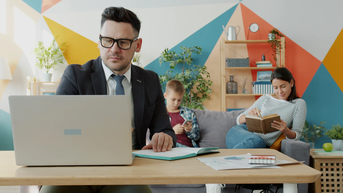 A man working on a laptop at home while a woman reads and a boy uses a phone on the sofa behind him